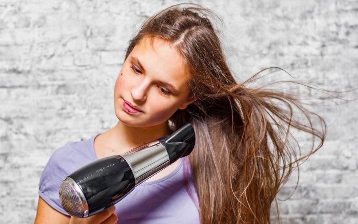 Meisje dat haar haar aan het drogen is