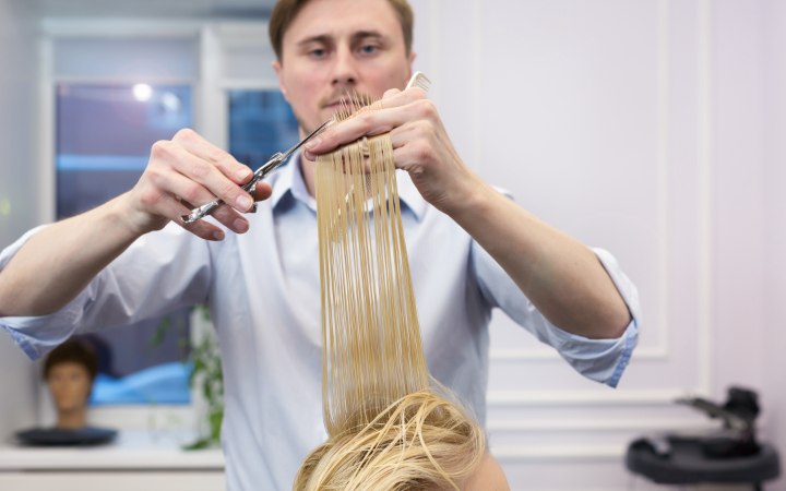 Kapper die de punten van lang haar bijknipt